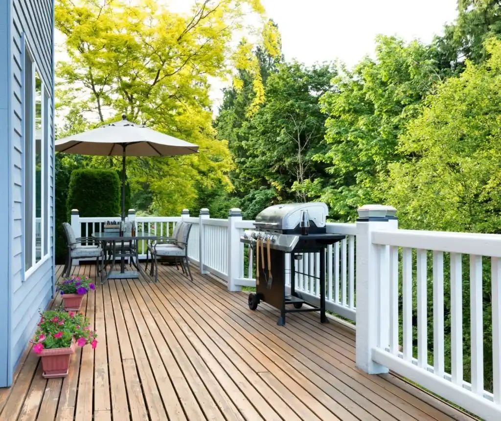 White vinyl deck railing surrounding a residential wood deck with outdoor furniture