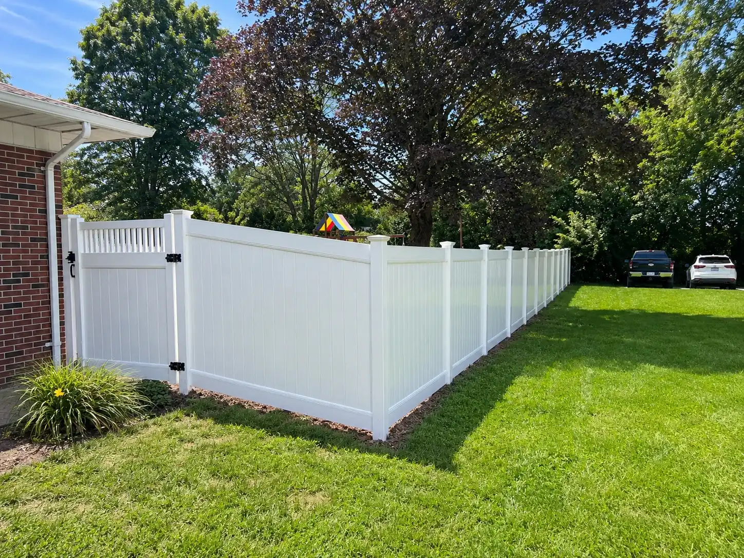 White vinyl privacy fence enclosing a backyard